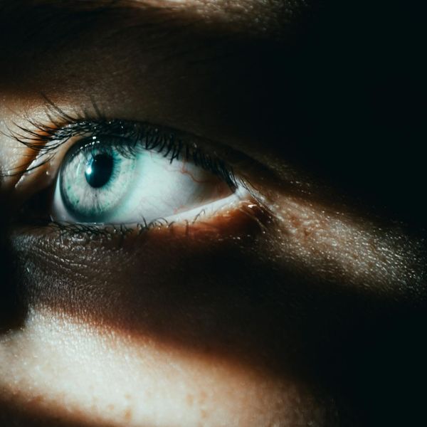 Close-up of a person's eye reflecting a serene natural landscape.